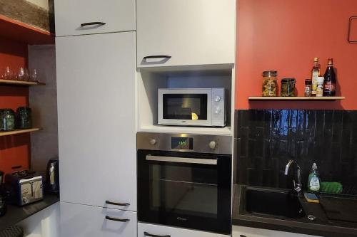 uma cozinha com um micro-ondas e um fogão em F2 au cœur de Langeais. em Langeais