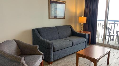 a living room with a couch and a chair and a table at Oceanfront Paradise in the Heart of Myrtle Beach in Myrtle Beach