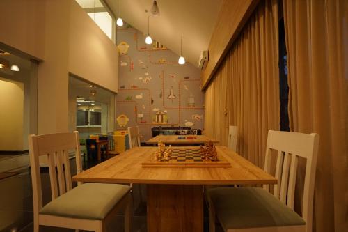une salle à manger avec un échiquier sur une table en bois dans l'établissement The Daman Club, à Daman