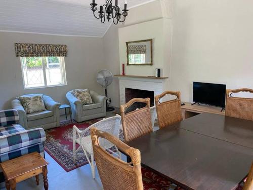a living room with a table and chairs and a fireplace at Gartmore Guest Farm in Howick