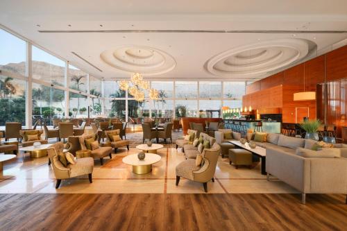 a lobby of a hotel with chairs and tables at Nevo by Isrotel Collection in Ein Bokek