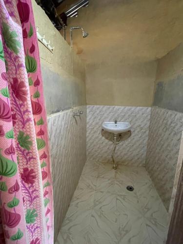 La salle de bains est pourvue d'un lavabo et d'une douche. dans l'établissement Prem Bardiya Homestay, à Bākhri Kharka