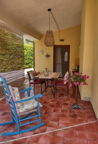 Casa Mimosa Holiday Room في سبرلونغا: فناء فيه كراسي وطاولة و قلادة