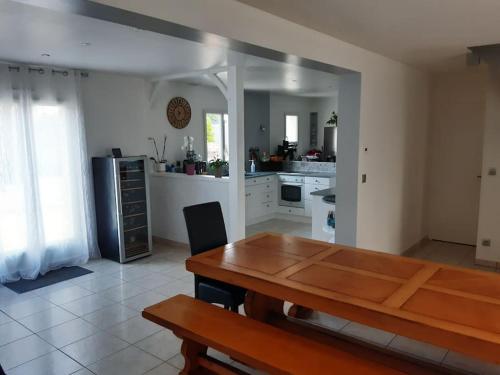 a kitchen with a wooden table in the middle of it at Villa Folie Douce, accueille 10 pers avec Piscine in Réthôville