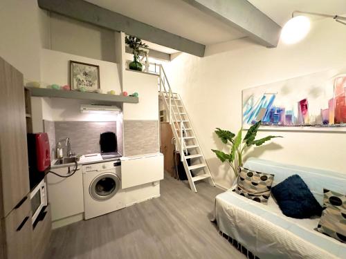 uma sala de estar com uma máquina de lavar roupa e uma escada em Le repaire des voyageurs em Port Leucate