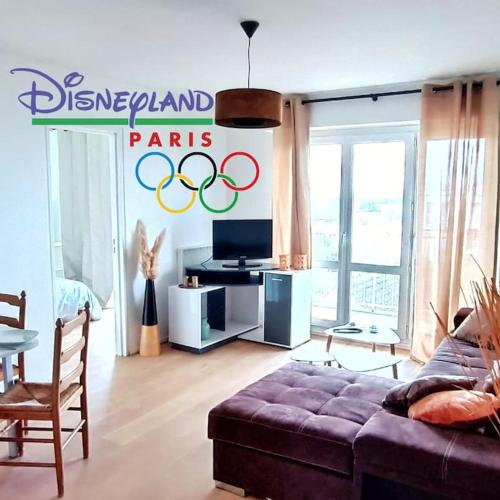 ein Wohnzimmer mit Sofa und ein Schild, das die Medaillen liest in der Unterkunft Paris / Disney 6 Personnes in Noisy-le-Grand