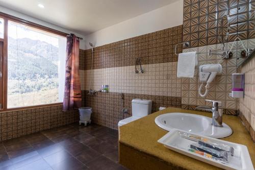 ニューデリーにあるSMART PLAZA HOTEL-At Airportのバスルーム(洗面台、トイレ付)、窓が備わります。