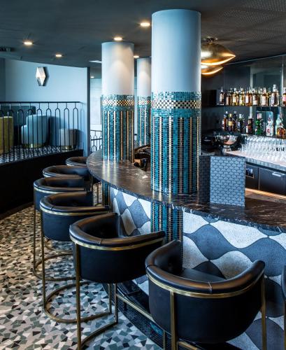 a bar with a row of stools in a room at Castelbrac Hotel & Spa in Dinard