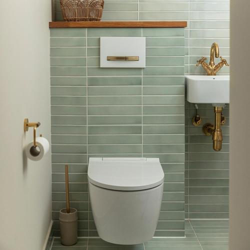 a bathroom with a white toilet and a sink at Grønbechs Hotel in Allinge