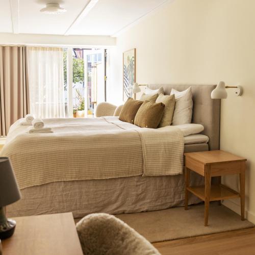 a bedroom with a large bed and a window at Grønbechs Hotel in Allinge