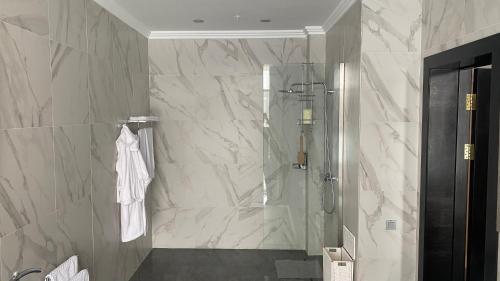 a bathroom with a shower with a glass door at Hotel Burabay in Shchūchīnsk