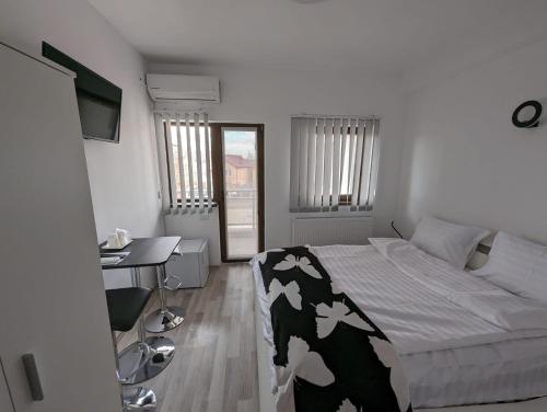 a bedroom with a bed with a cow blanket on it at 2Family in Focşani