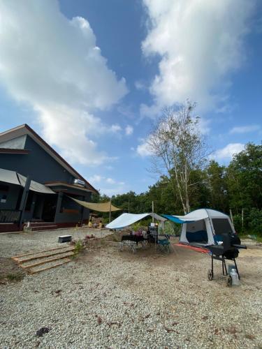 une tente et un hélicoptère garés à côté d'un bâtiment dans l'établissement AzHAUZ Guestroom & Campsite, à Kampong Kemaman