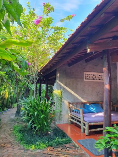 a porch of a house with a bench under a roof at An Bang Hideaway in Hoi An