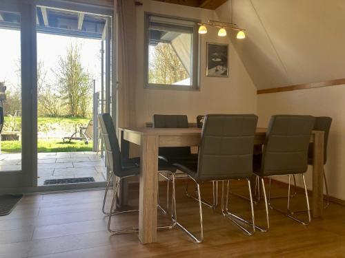 a dining room with a wooden table and chairs at Holiday House Platz an der Sonne for 6 people near Lake Lauwersmeer in Oostmahorn