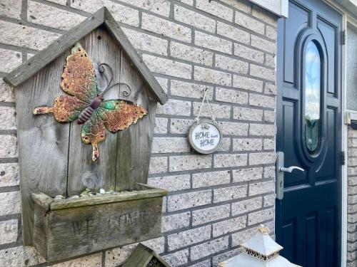 a butterfly on a bird house on a brick wall at Dijkrose in Oostmahorn