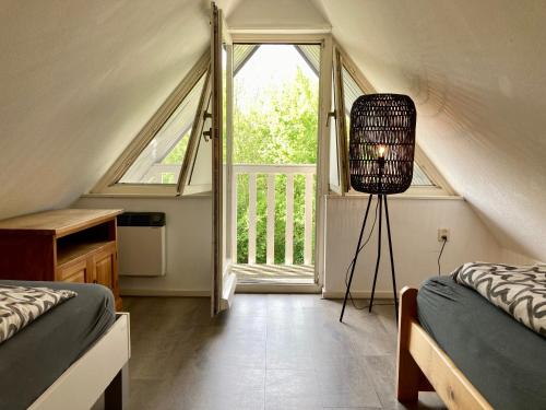 1 Schlafzimmer mit 2 Betten und einem großen Fenster in der Unterkunft Olivia 6pers House with a private garden close to the National Park Lauwersmeer in Anjum