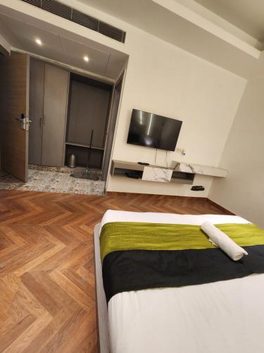 um quarto com uma cama e uma televisão de ecrã plano em Squar Stays em Gurgaon