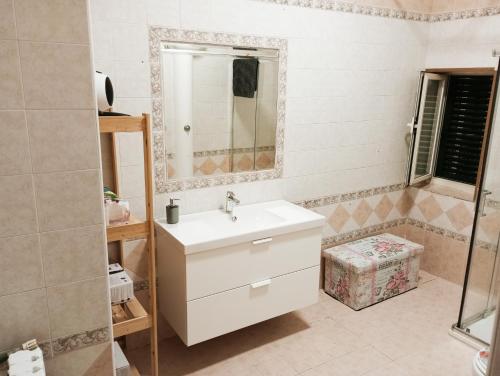 y baño con lavabo blanco y espejo. en Spaccanapoli house en Nápoles