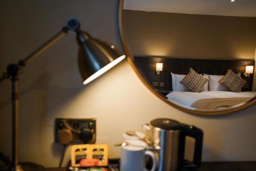 a hotel room with a bed and a mirror at Park hall Hotel & Spa Lancashire, a member of Radisson Individuals in Eccleston