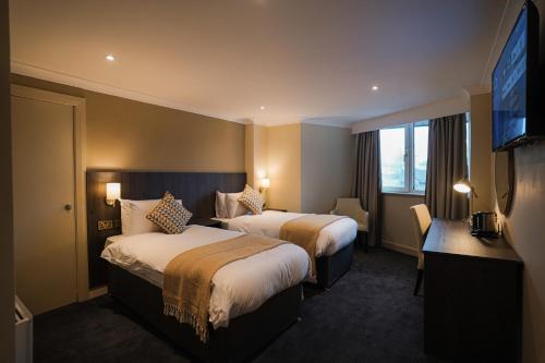 Habitación de hotel con 2 camas y TV de pantalla plana. en Park Hall Hotel,Chorley,Preston, en Eccleston