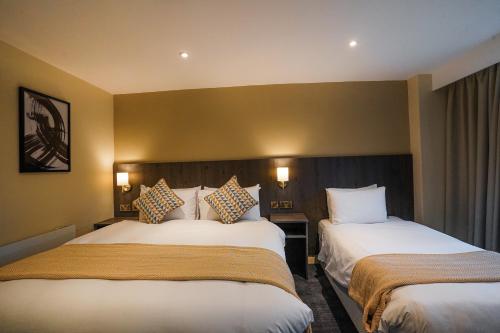 a hotel room with two beds and two lamps at Park hall Hotel & Spa Lancashire, a member of Radisson Individuals in Eccleston