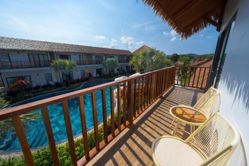 a balcony with two chairs and a swimming pool at Greenlife Village Phú Quốc in Phu Quoc