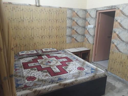 a bedroom with a bed with a quilt on it at Mahesh Guest House Ajmer in Ajmer