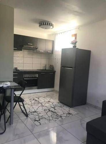 uma cozinha com um frigorífico preto e uma mesa em Appartement au RDC d’une maison em Privas