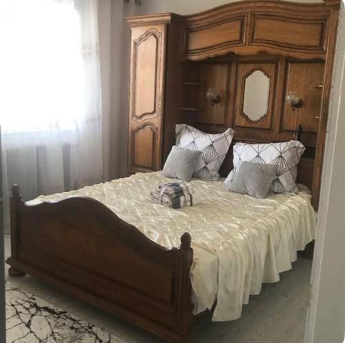 um quarto com uma cama grande e uma cabeceira em madeira em Appartement au RDC d’une maison em Privas