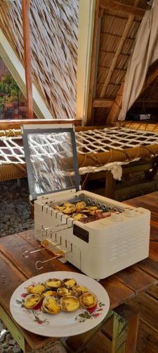 a box of fruit on a table with a plate at ALCAVA Rustic Kubo Huts in Dipolog