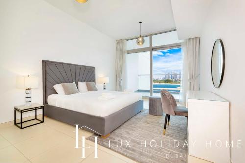 a bedroom with a bed and a desk and a window at LUX - Opulent Island Suite 4 in Dubai