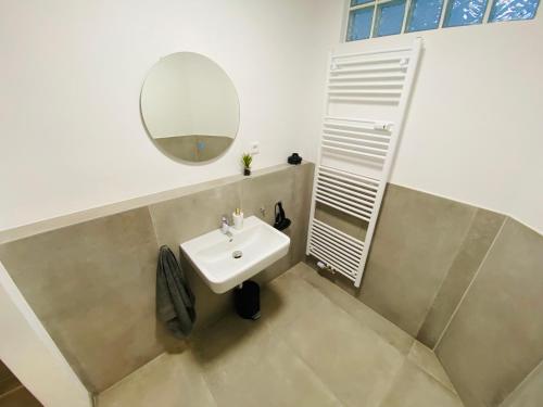 ein Bad mit einem Waschbecken und einem Spiegel in der Unterkunft Charming Apartments l 7 Beds l 4 Bedrooms l WI-FI in Geseke