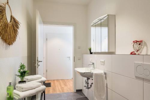 a white bathroom with a sink and a mirror at Mina 