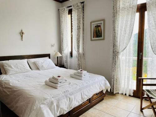 - une chambre avec un lit et des serviettes dans l'établissement Voutyro Residence I, Karpenisi, Evrytania, à Karpenísi