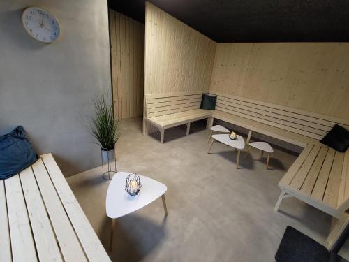 a room with benches and tables and a clock on the wall at Švihák lázeňský in Velké Losiny