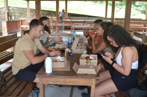 モシにあるKilibase Hotelのテーブルに座って食事を楽しむ人々のグループ