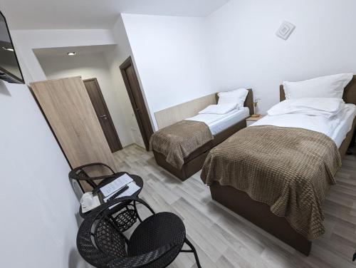 a hotel room with two beds and a chair at 2Family in Focşani