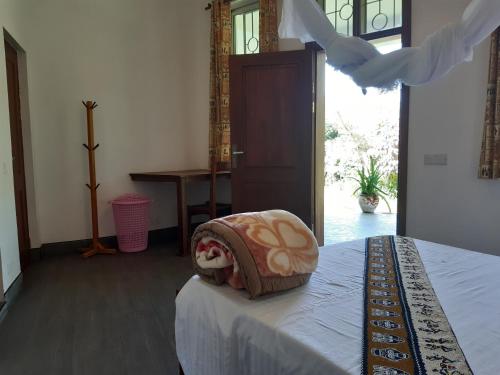 a bedroom with a bed with a blanket on it at Themi View in Arusha