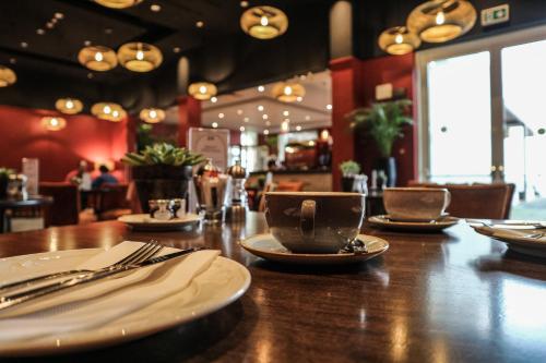a table in a restaurant with plates and cups on it at Hotel de France in Saint Helier Jersey