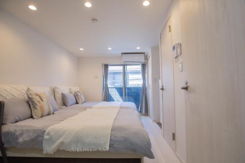 a bed in a room with a window at Shinjuku Ryokan Retreat丶Local Tokyo Experience & Short Trips Hub丶walk to Shinjuku station EoE4 in Tokyo