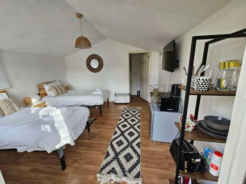 a bedroom with two beds and a room with a mirror at Willow by Paymán Club in Royston