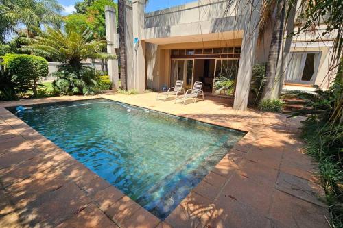 a swimming pool in front of a house at Grobler's Haven in Pretoria