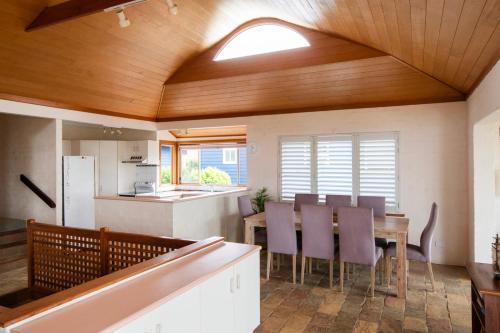 a kitchen and dining room with a table and chairs at Sandilands One - Oceanstays in Yamba