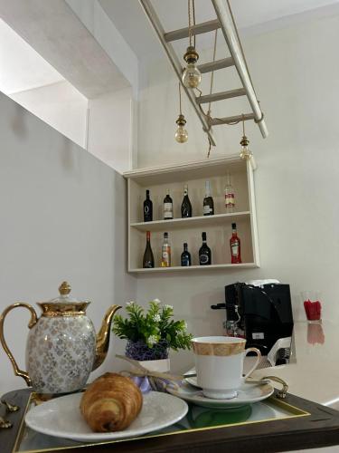 a table with a plate with a croissant and a cup of coffee at Olimpo B&B in Giurdignano