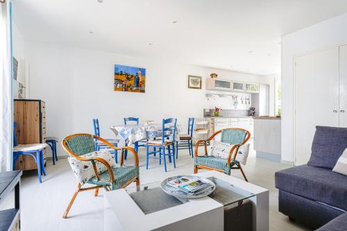un salon avec une table et des chaises dans l'établissement Maison proche mer, forêt,bourg, à Grand-Village-Plage