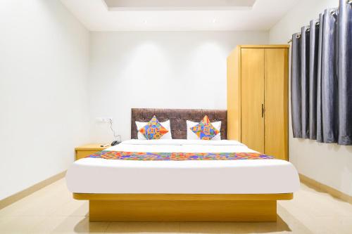 1 dormitorio con 1 cama grande en una habitación en FabHotel Aashiyana, en Indore