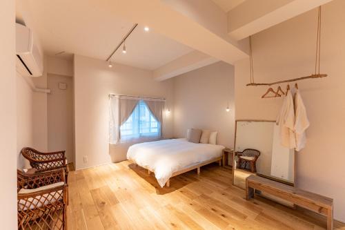 1 dormitorio con cama y ventana en hotel & cafe ksnowki, en Dejimamachi
