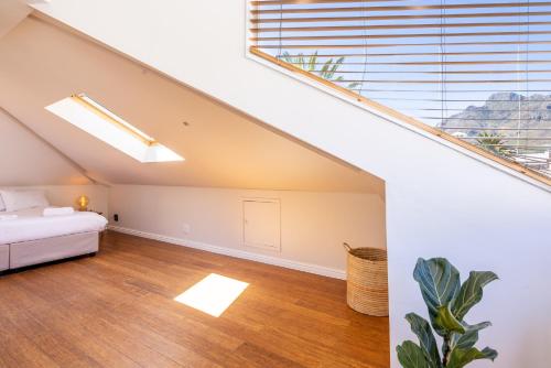 an attic bedroom with a bed and a large window at Villa Viva Cape Town in Cape Town