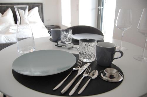 a table with a plate and silver utensils on it at myQuartier Luxury Hideaways in Innsbruck